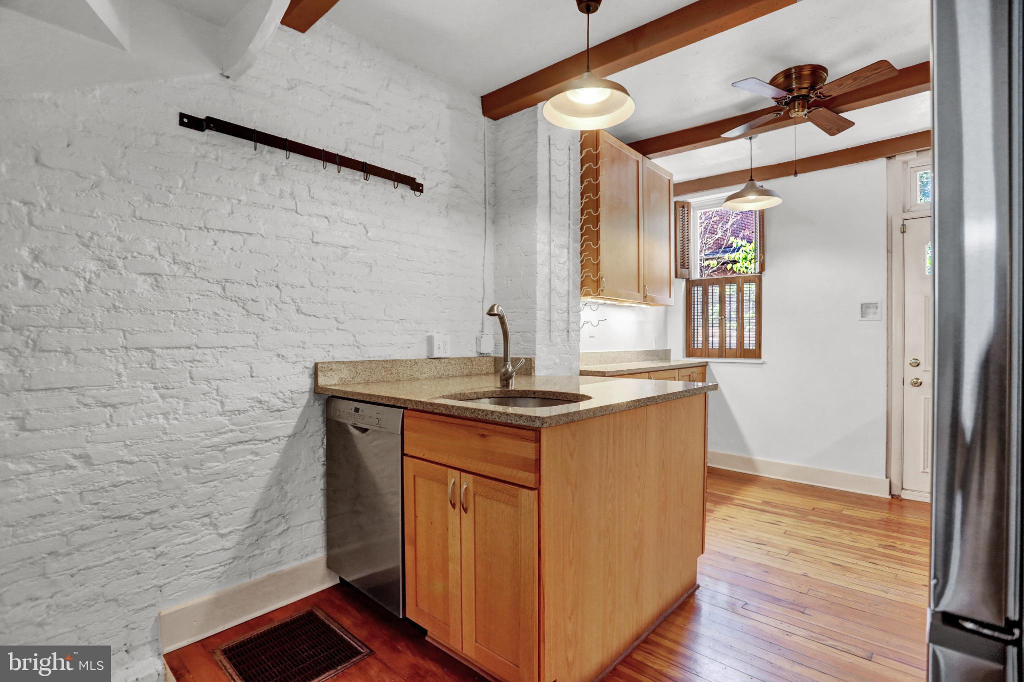 1306 Rutter Street Baltimore, MD 21217 - Photo 7 of 27 a utility room with granite countertop a sink and a wooden floor