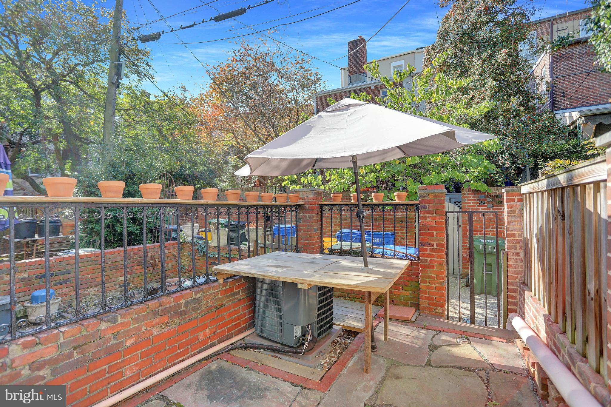 1306 Rutter Street Baltimore, MD 21217 - Photo 9 of 27 a view of a patio with a table and chairs under an umbrella with wooden fence