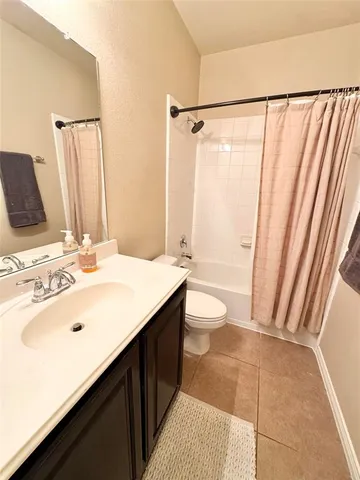 a bathroom with a sink a toilet a mirror and shower