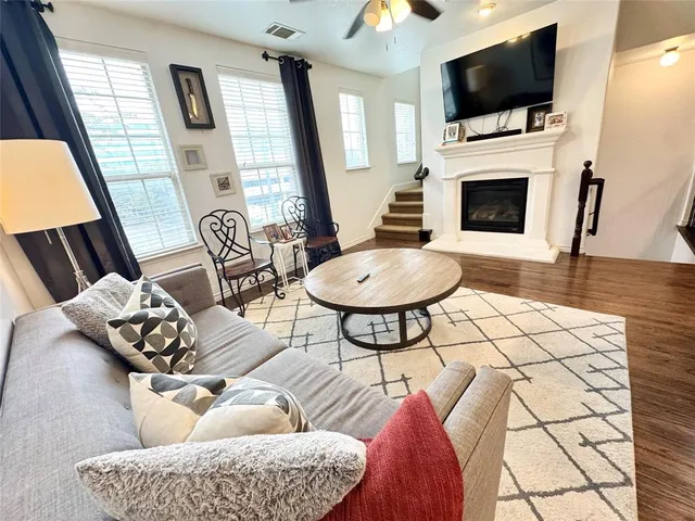 a living room with furniture a flat screen tv and a fireplace