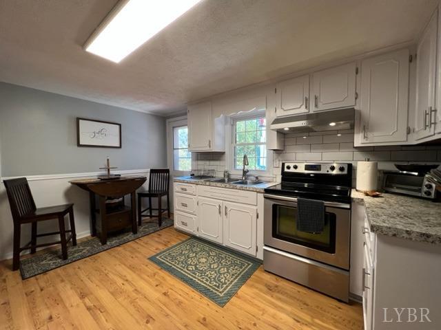 7338 Red House Road Appomattox, VA 24522 - Photo 4 of 28 a kitchen with stainless steel appliances kitchen island granite countertop a stove a sink and a microwave