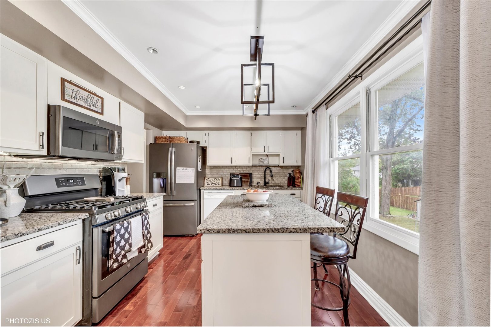 1352 West Oakmont Road Hoffman Estates, IL 60169 - Photo 19 of 42 a kitchen with stainless steel appliances granite countertop a stove top oven a sink dishwasher a dining table and chairs with wooden floor