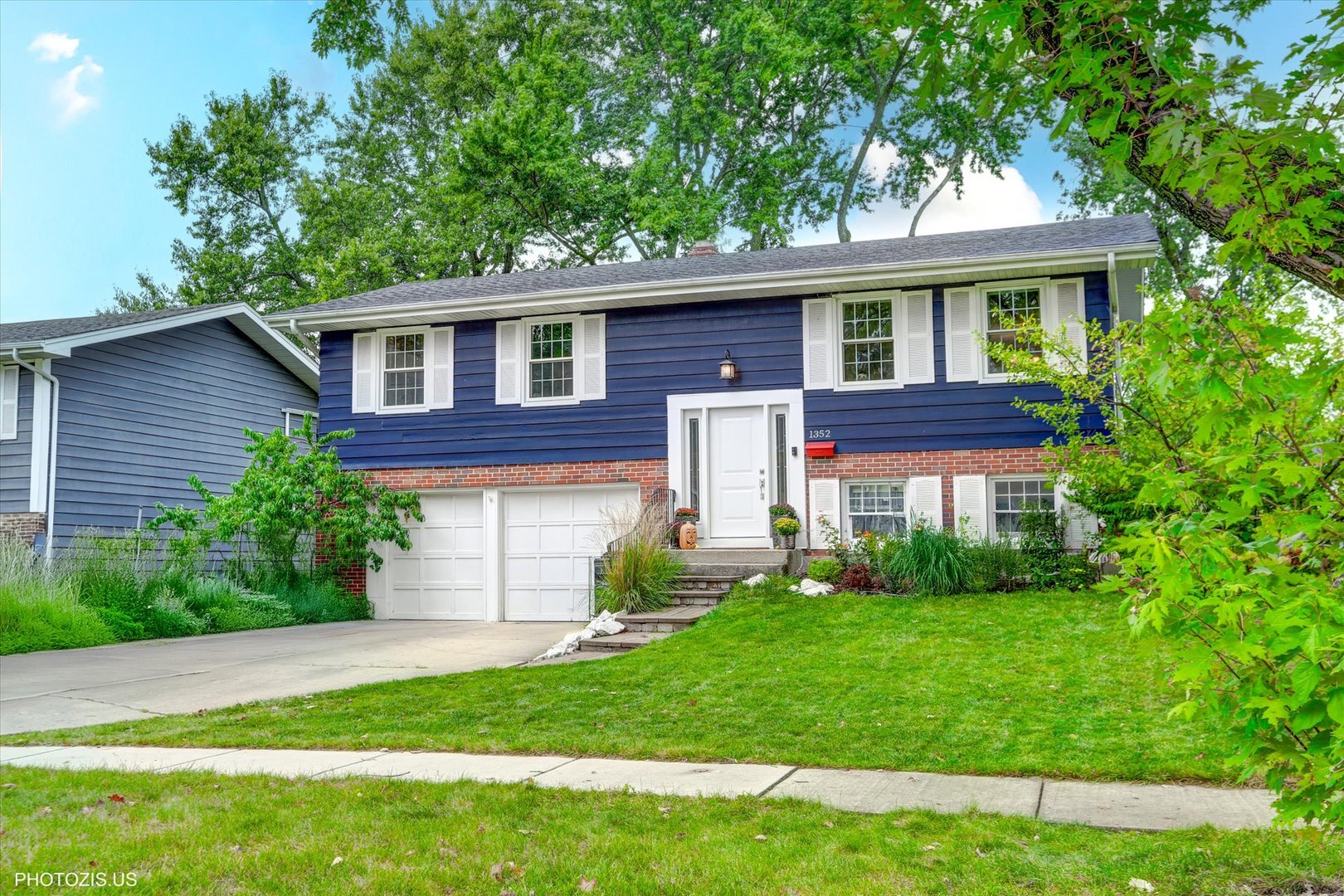 1352 West Oakmont Road Hoffman Estates, IL 60169 - Photo 2 of 42 a front view of a house with a garden and plants