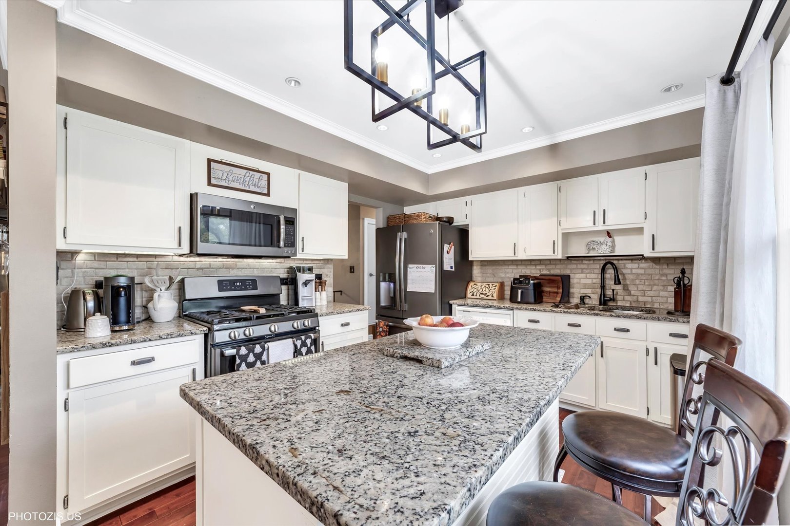 1352 West Oakmont Road Hoffman Estates, IL 60169 - Photo 22 of 42 a kitchen with stainless steel appliances granite countertop a stove top oven a sink dishwasher a dining table and chairs with wooden floor