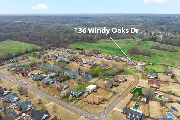 a view of an empty room with wooden floor fireplace and a window