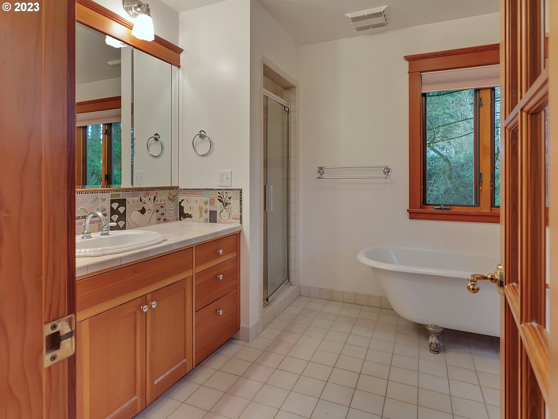 11310 Northwest Plainview Road Portland, OR 97231 - Photo 20 of 32 a spacious bathroom with a double vanity sink a mirror and a bathtub