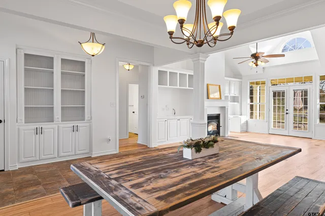 a view of a livingroom with furniture a fireplace wooden floor and a chandelier