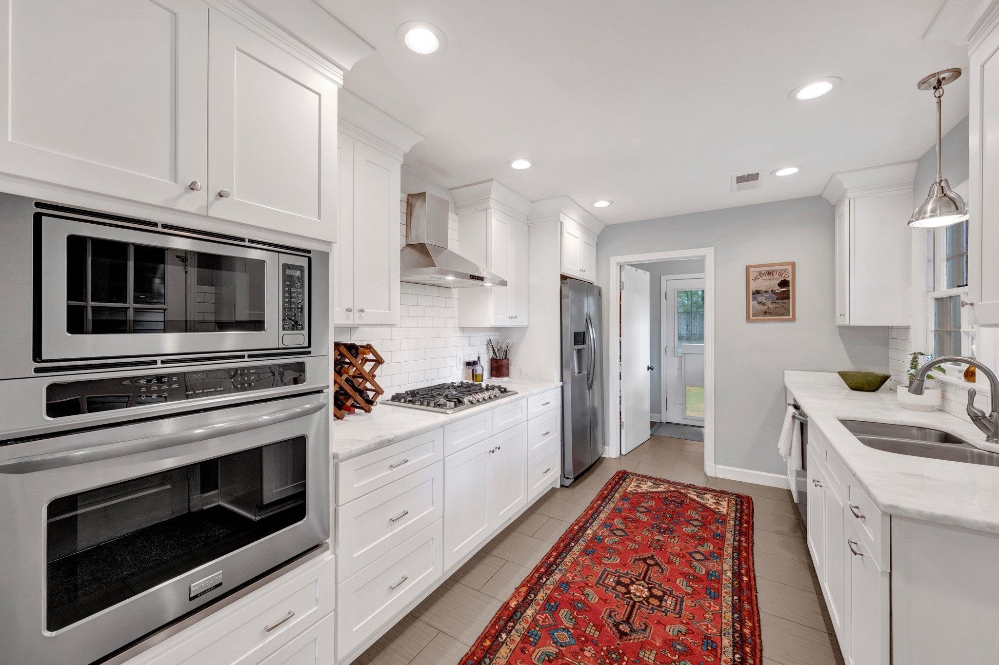 5543 Walnut Grove Road Memphis, TN 38120 - Photo 11 of 25 a kitchen with stainless steel appliances white cabinets and a stove top oven