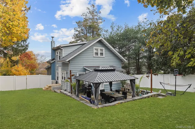 a view of a house with a big yard and large trees