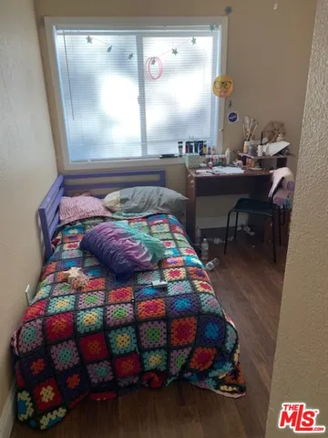 a bedroom with a bed that has a blanket on it and next to a window