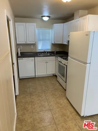a kitchen with a refrigerator sink and cabinets