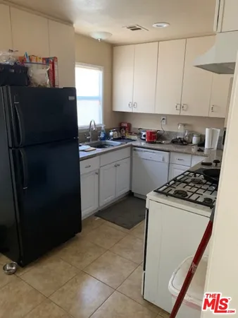a kitchen with granite countertop a refrigerator stove and sink