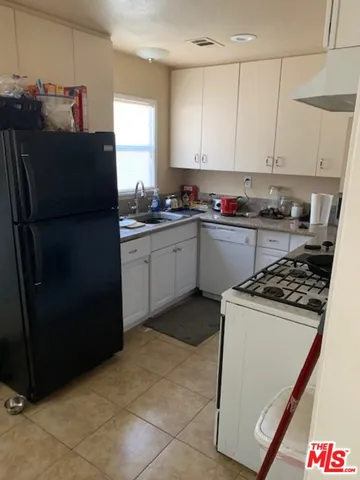 a kitchen with granite countertop a refrigerator stove and sink