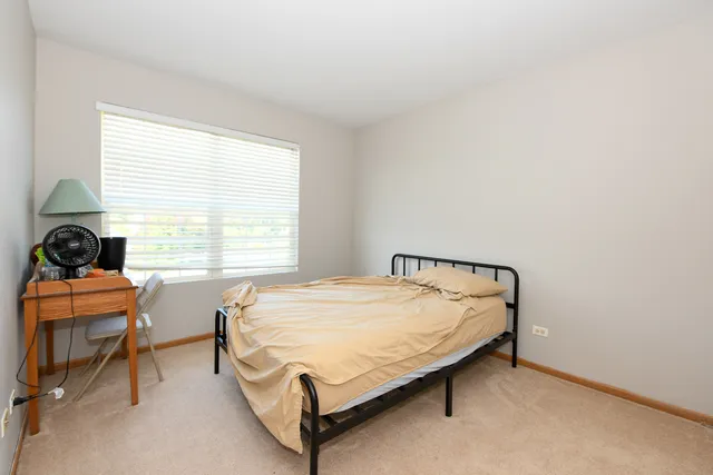 a bed sitting in a bedroom next to a window