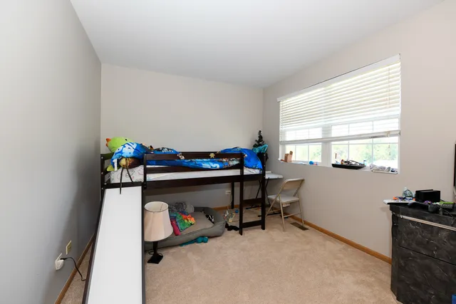 a bedroom with bunk bed and a window