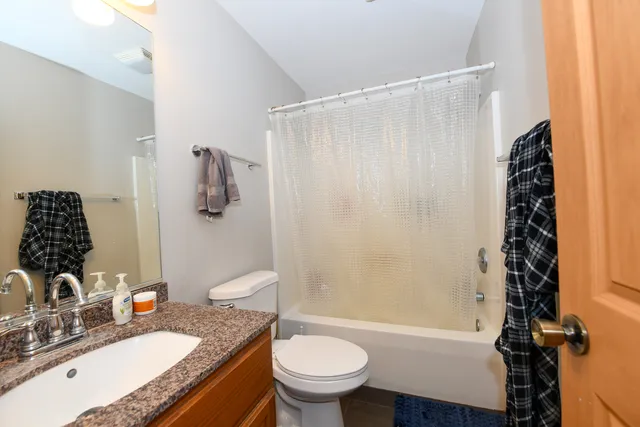 a bathroom with a granite countertop sink toilet and shower
