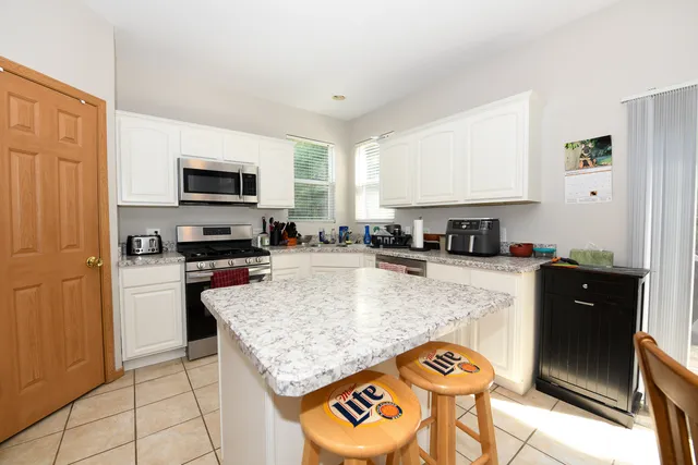 a kitchen with stainless steel appliances granite countertop a stove top oven a sink a counter space and cabinets