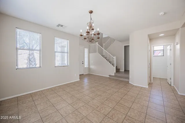 an empty room with chandelier and windows