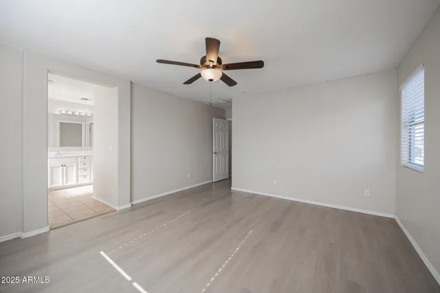 an empty room with windows and fan
