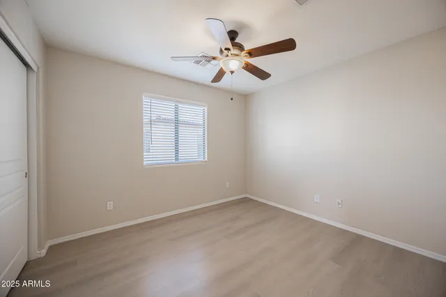 an empty room with a window and a fan