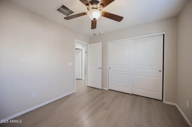 an empty room with a ceiling fan and carpet