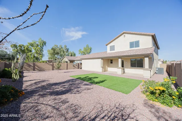 a front view of a house with a yard and potted plants