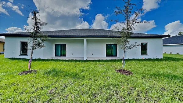 a view of a house with backyard and a garden