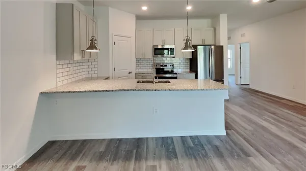 a kitchen with stainless steel appliances a refrigerator and a stove top oven
