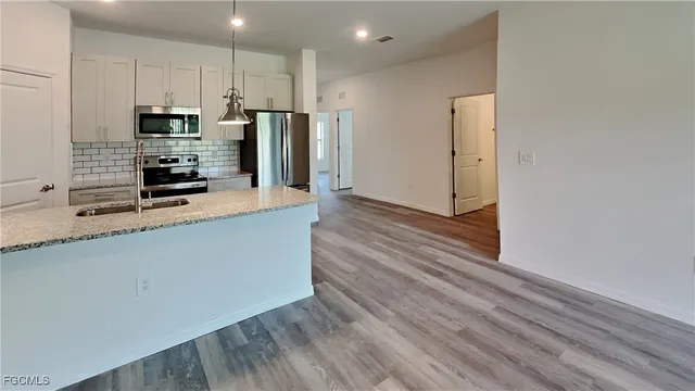 a kitchen with stainless steel appliances a refrigerator and a stove top oven