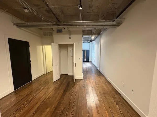 a view of empty room with wooden floor