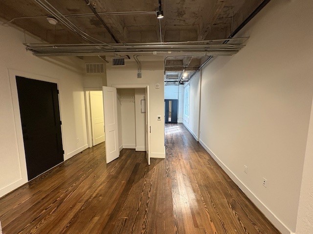 a view of empty room with wooden floor