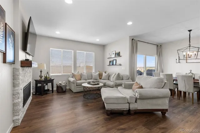 a kitchen with stainless steel appliances granite countertop a sink a stove a refrigerator and a dining table with wooden floor