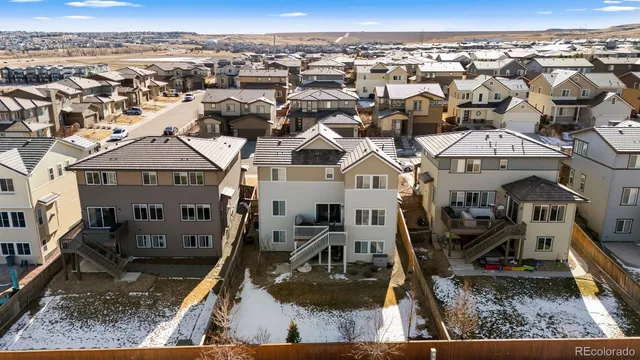 a kitchen with stainless steel appliances granite countertop a dining table chairs refrigerator and sink