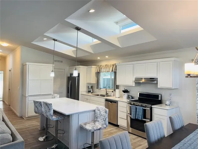 a living room with stainless steel appliances kitchen island granite countertop furniture and a kitchen view