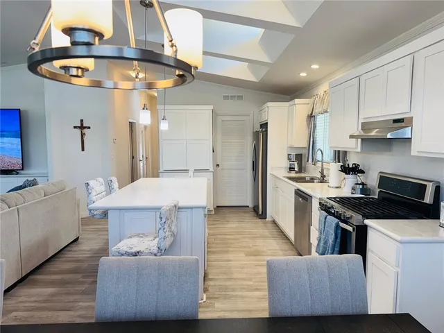 a view of a dining room with furniture a chandelier and wooden floor
