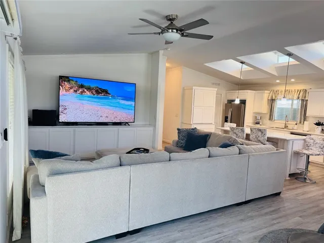 a living room with furniture kitchen view and a large window