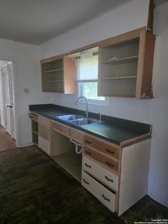 a kitchen with granite countertop a sink and a stove