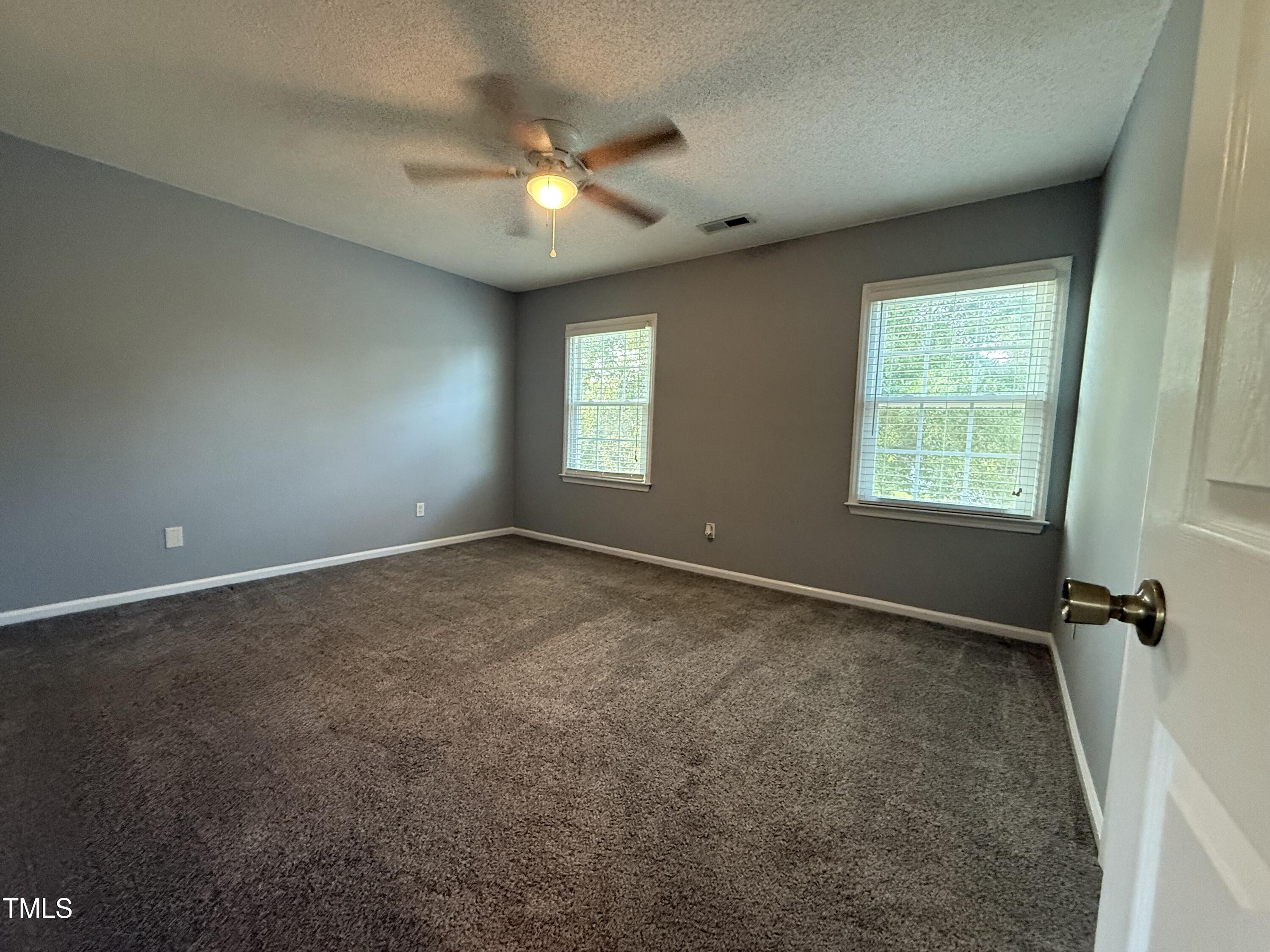 152 Christopher Avenue Princeton, NC 27569 - Photo 18 of 24 an empty room with windows and fan
