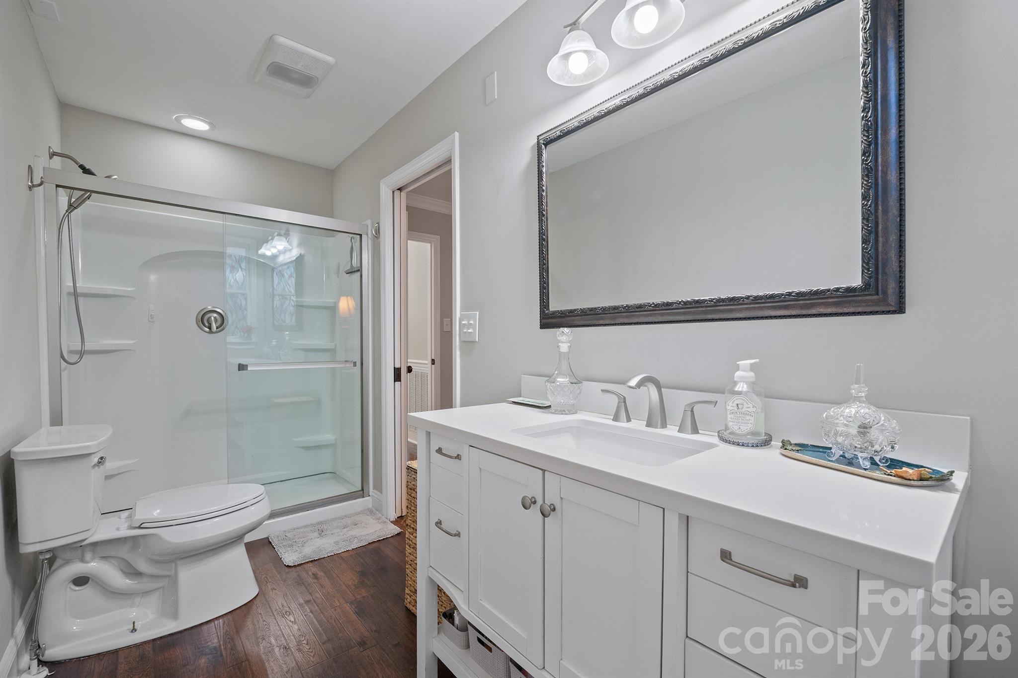 19017 Kailua Circle Tega Cay, SC 29708 - Photo 24 of 46 a bathroom with a toilet a sink a glass door a shower a mirror and vanity