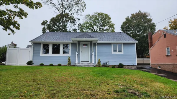 a front view of a house with a yard and trees