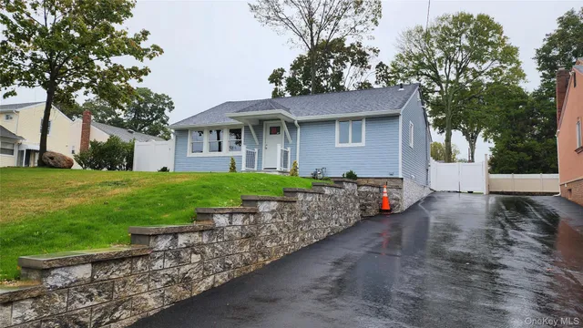 a view of a house with a yard and large tree