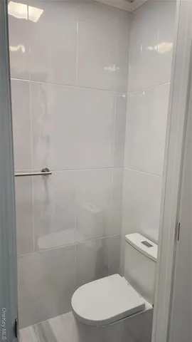 a white toilet sitting next to a shower