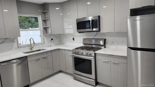 a kitchen with stainless steel appliances a refrigerator sink and microwave