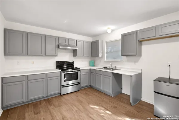 a kitchen with a sink and a stove top oven