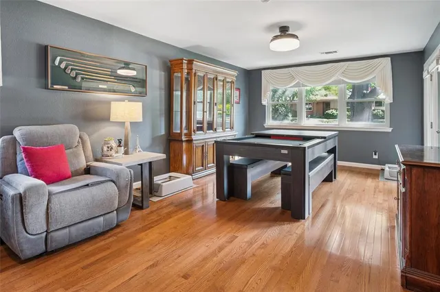 a living room with furniture a large window and wooden floor