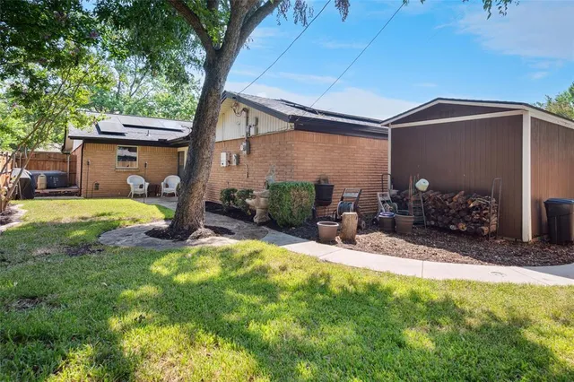 a view of a backyard with table and chairs under an umbrella