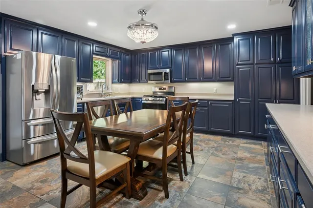 a kitchen with a table chairs refrigerator and cabinets