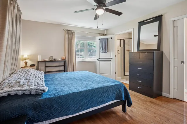 a bedroom with a bed and a dresser with mirror