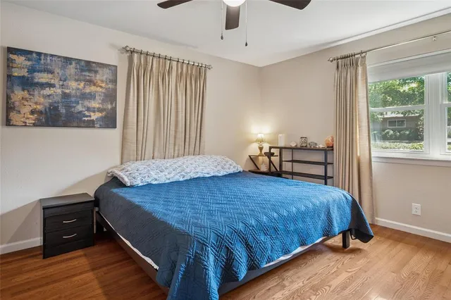 a bedroom with a bed and wooden floor