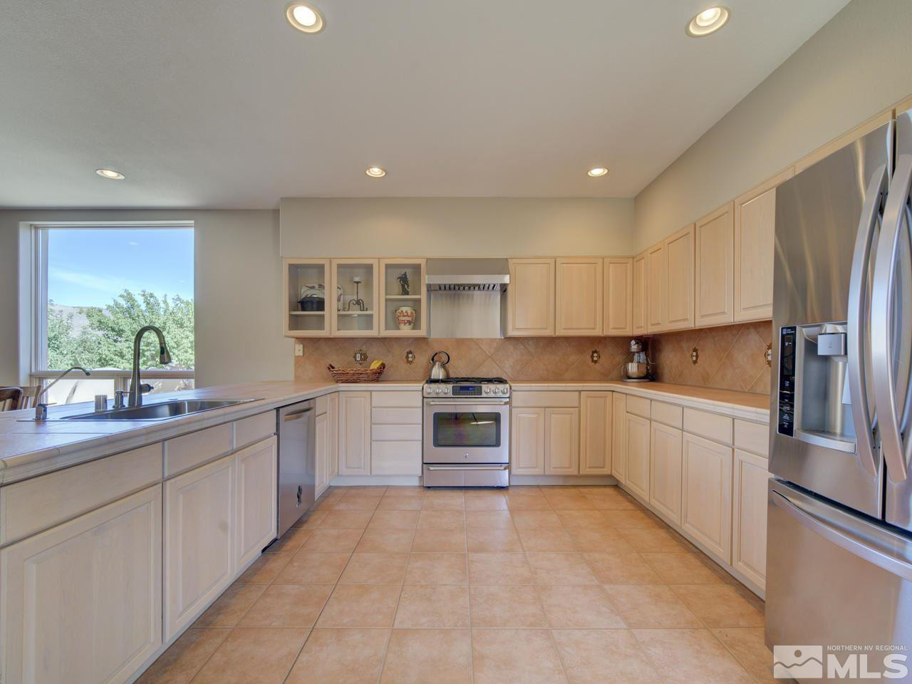 7280 Sage Canyon Road Reno, NV 89510 - Photo 7 of 23 a large kitchen with a large window and stainless steel appliances